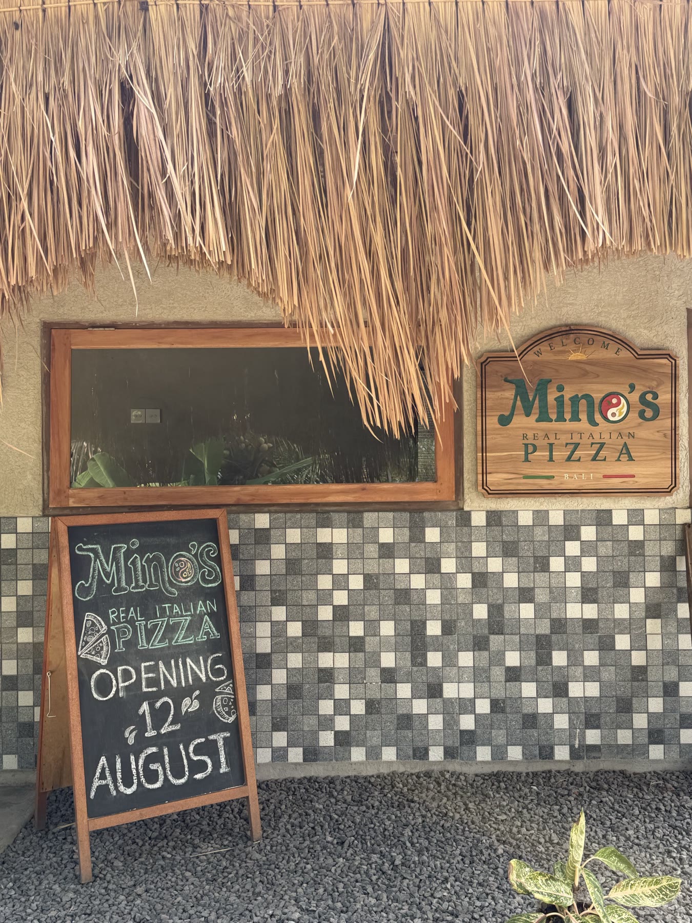 The Mino’s Pizza storefront and opening sign in Sayan
